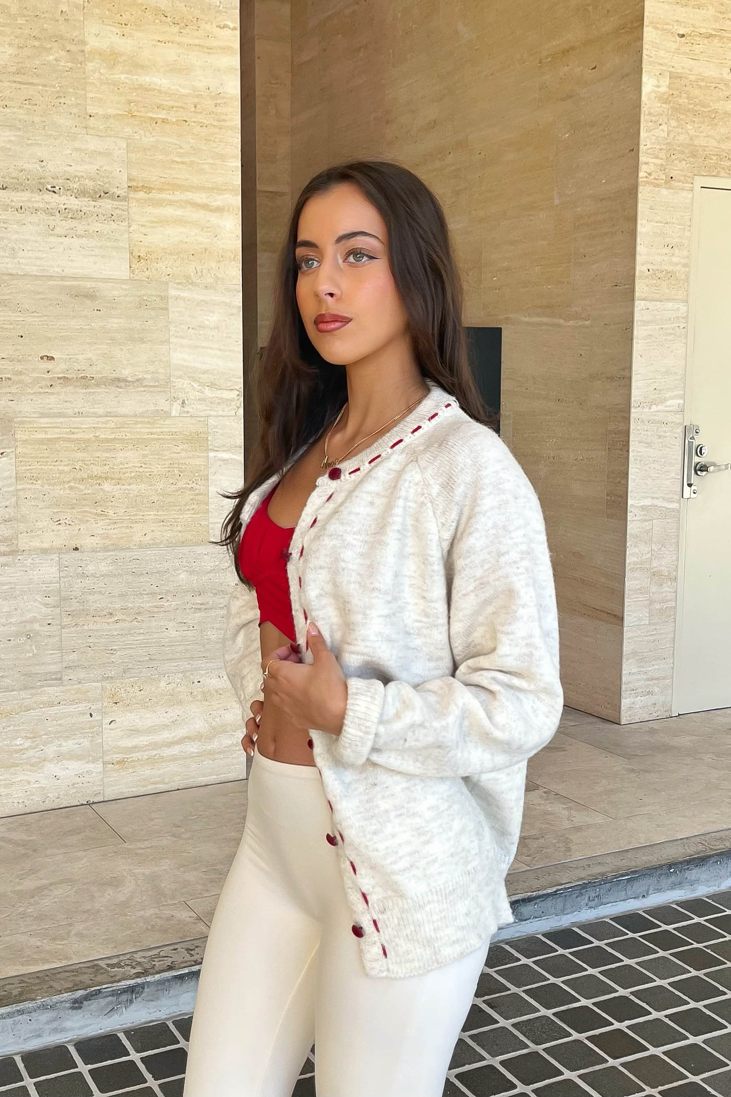 Cream cardigan with red stitching